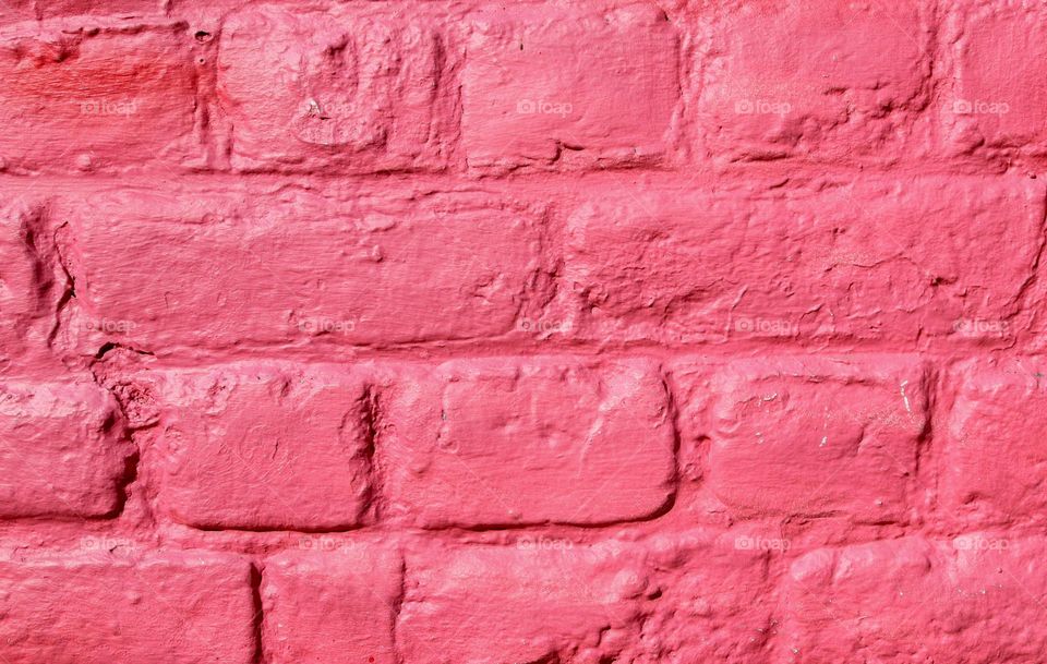 Beautiful brick background wall of mangent color, side view close-up. The concept of backgrounds, textures, wallpapers.