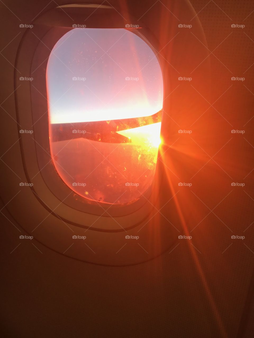 Sun on the wing in the airplane window 