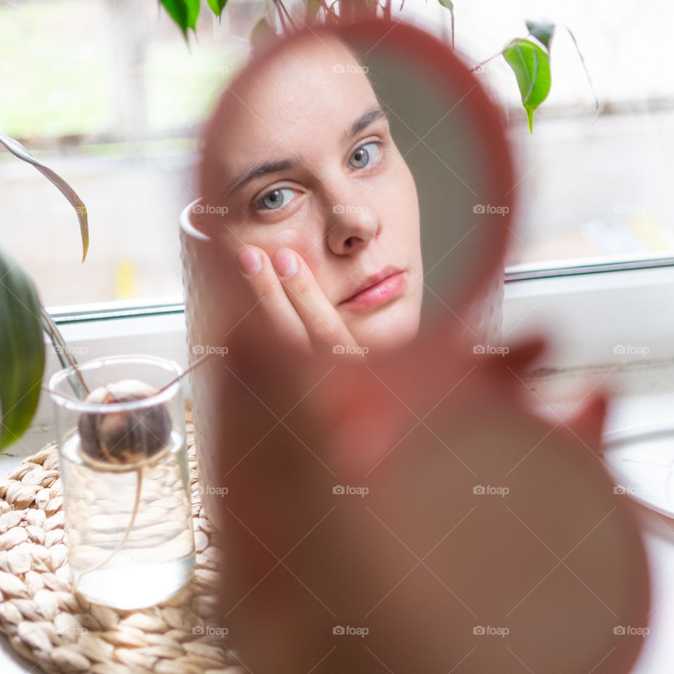 Young woman reflection in mirror making makeup