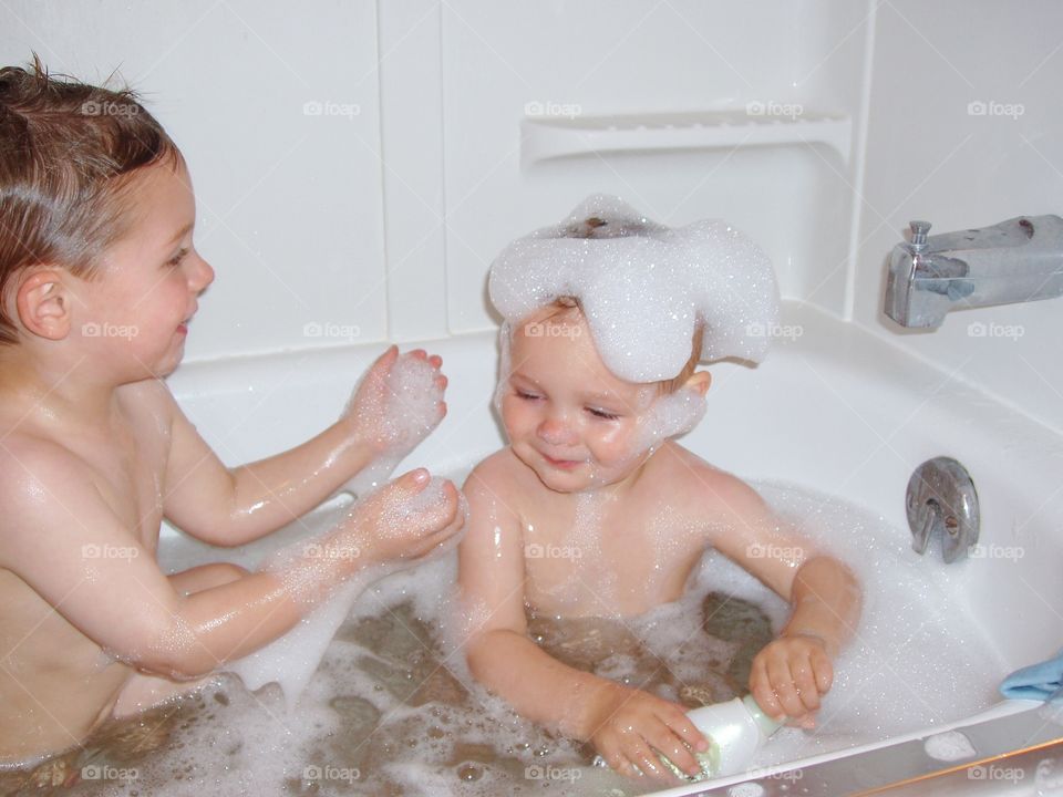 Brothers playing together in bathtub