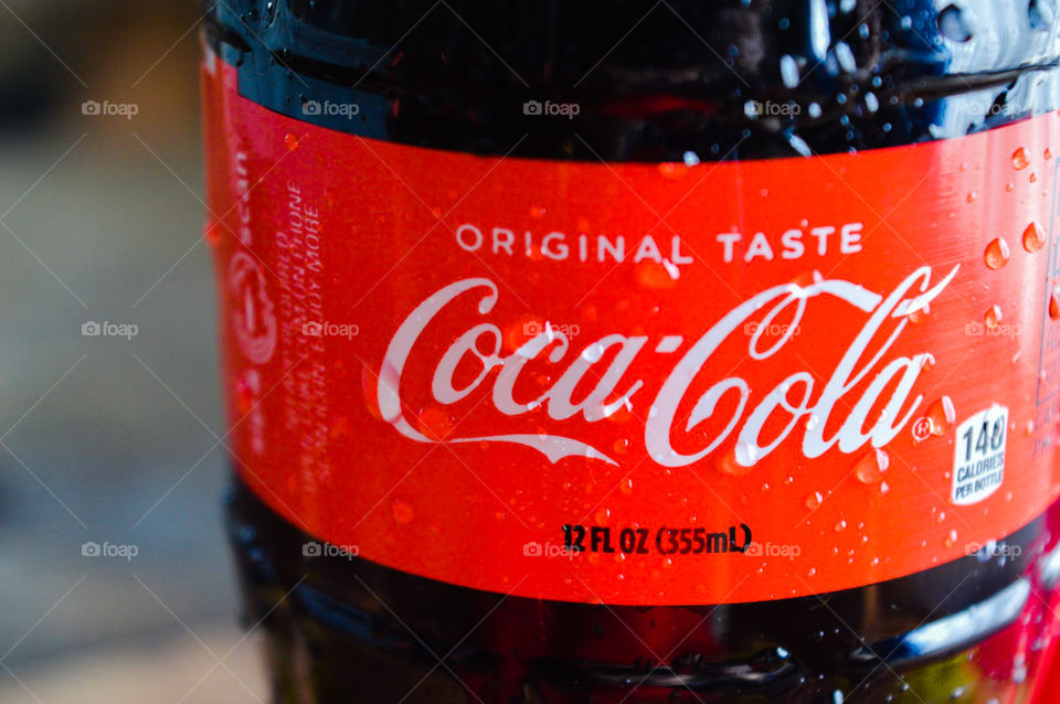 A plastic bottle of Coca-Cola with condensation