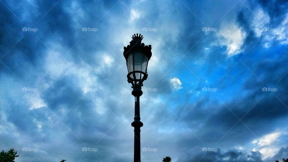 Street light against cloudy sky