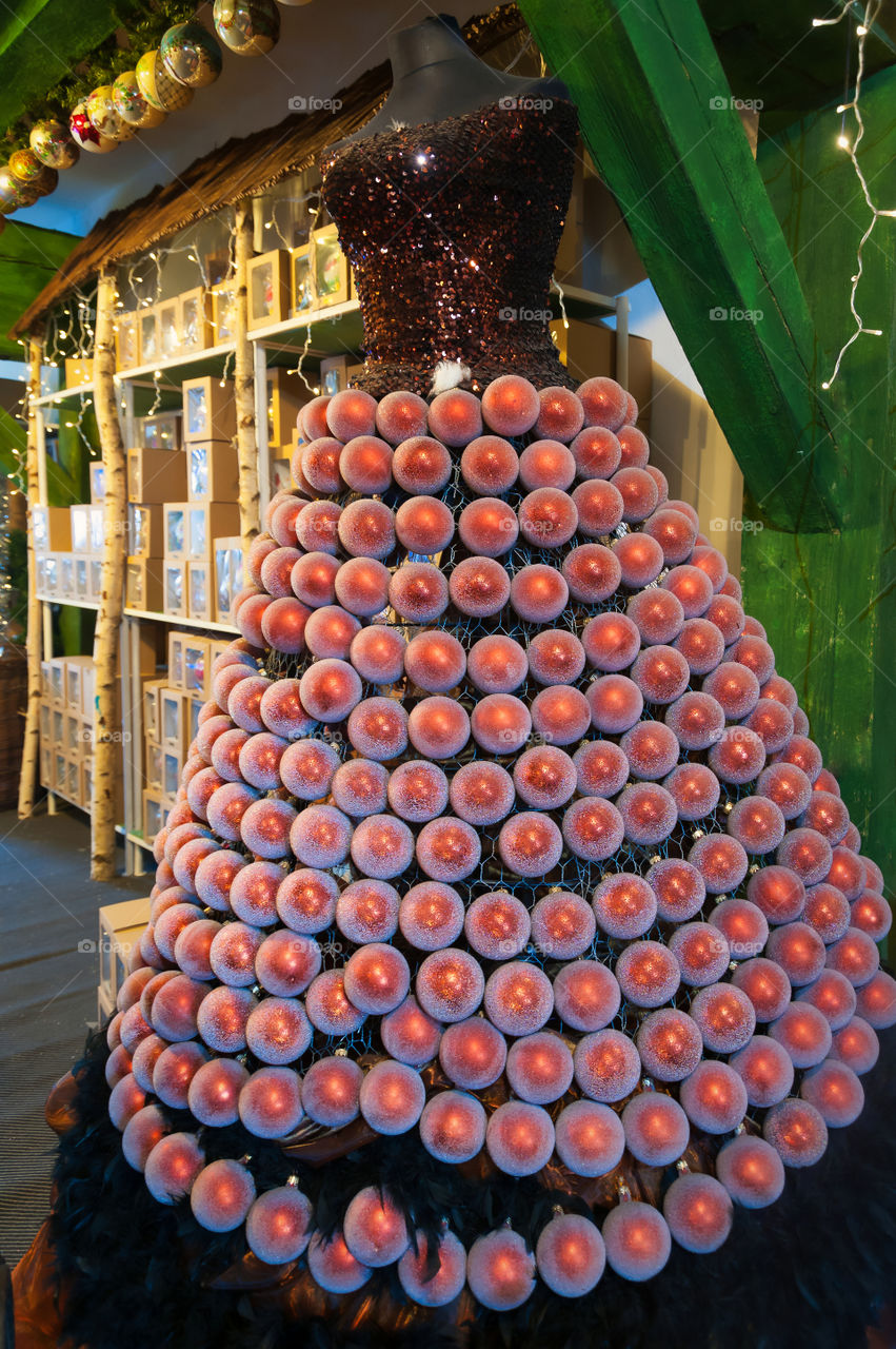 Beautiful dress made of Christmas baubles. Christmas ornaments on display inside manufacturer shop.