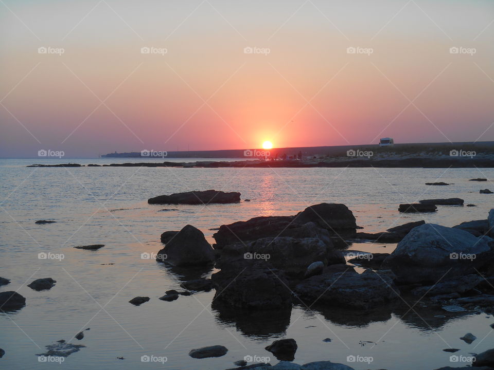 people resting on a sunset sea shore summer time