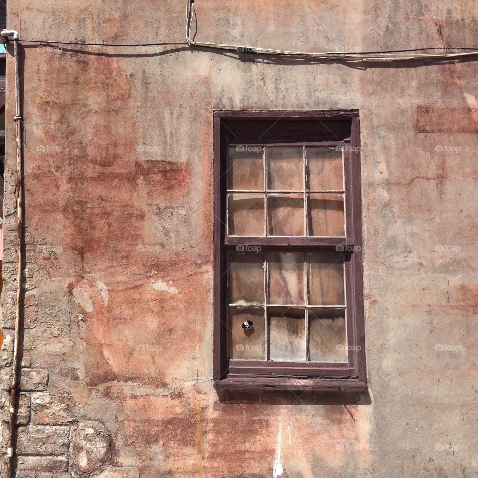 Wall with rust-colored patina and window in old St. Augustine, Florida