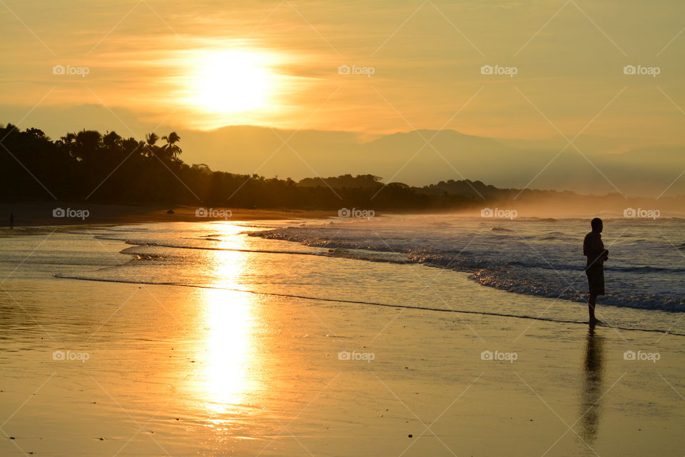 Costa Rica Sun Rise in the sleepy fishing village of Esterillo O Este. Reflections of the sun on the sandy shore welcome a new day.