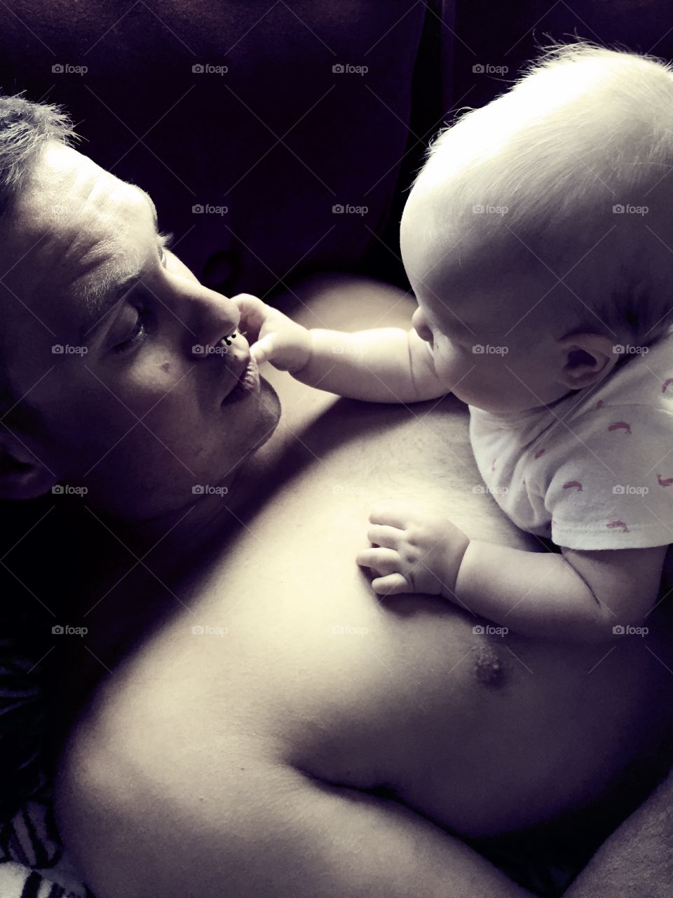 Close-up of a shirtless father with his baby