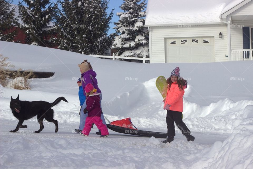 Family with their pet walking in snow