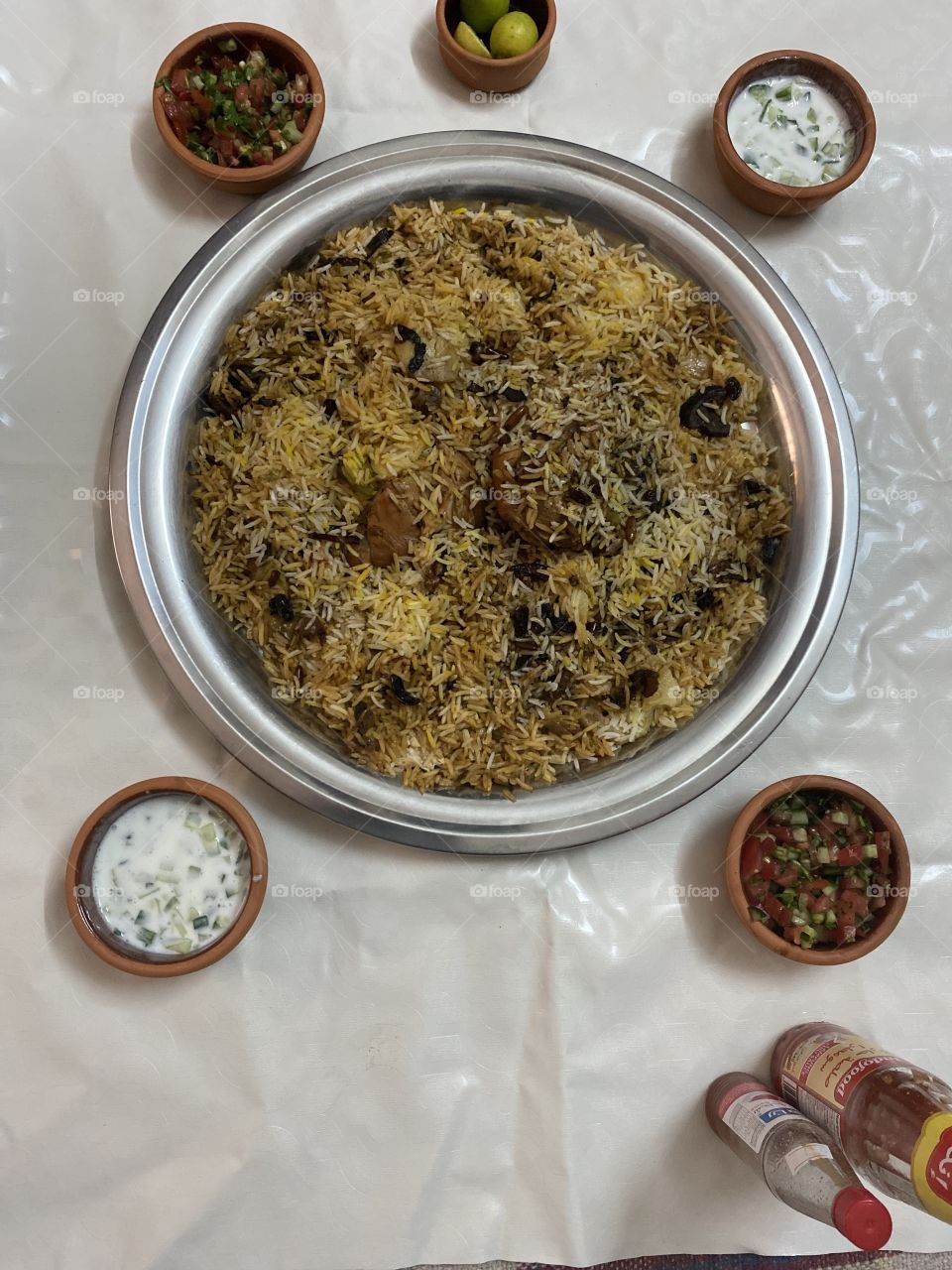 Upside-down kabsa with nuts, tomato and cucumber salad, yogurt and cucumber salad