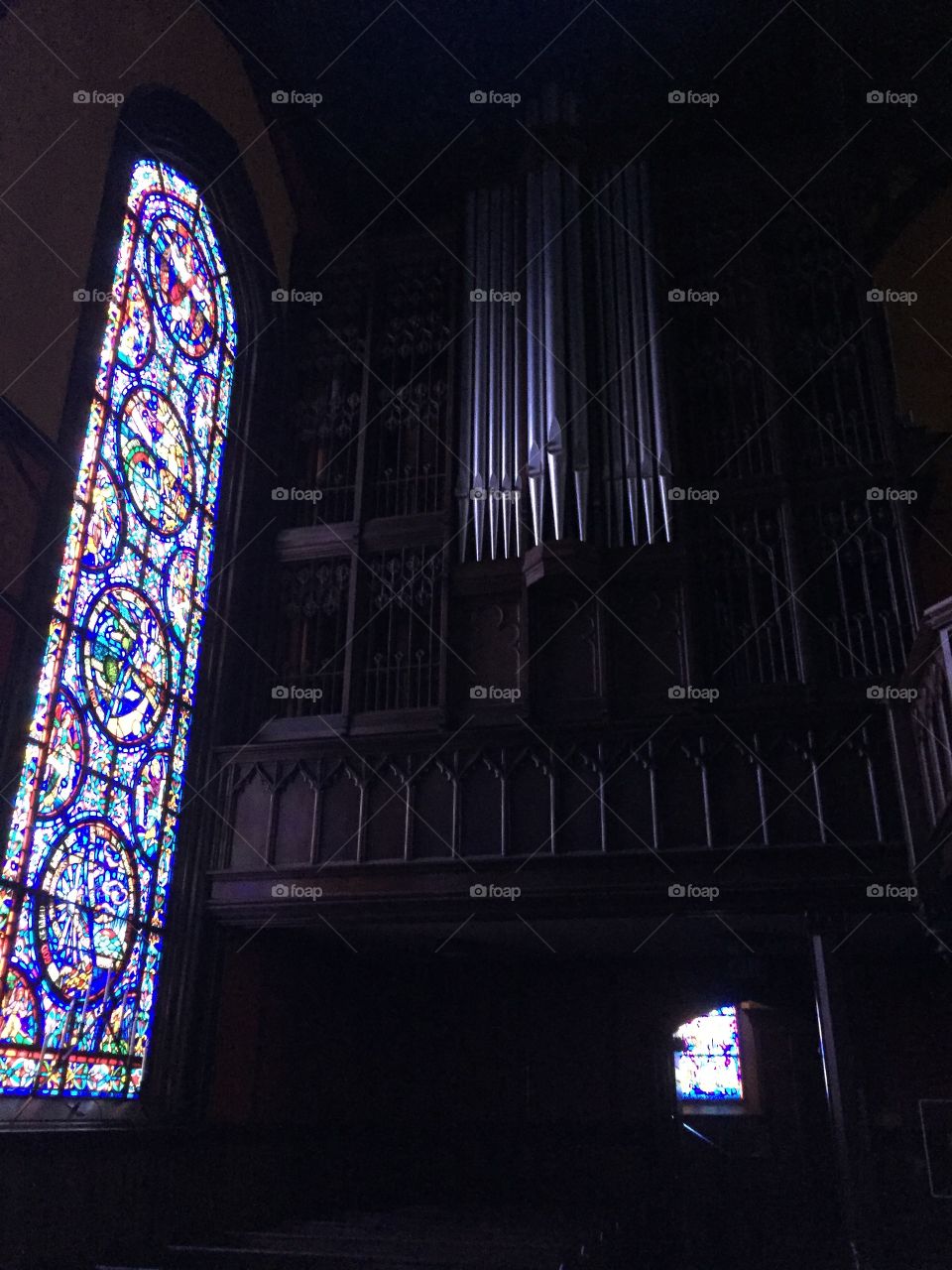 Stained glass and pipe organ in quiet sanctuary 