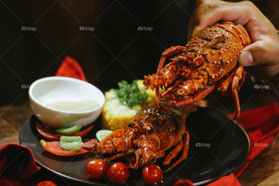 Lobster creamy garlic Lobster served with corn, tomatoes, lemon wedges, cherry and Asian-style creamy garlic sauce.