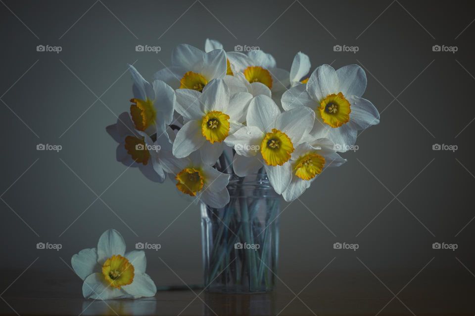 Bouquet of daffodil flowers in glass vase.