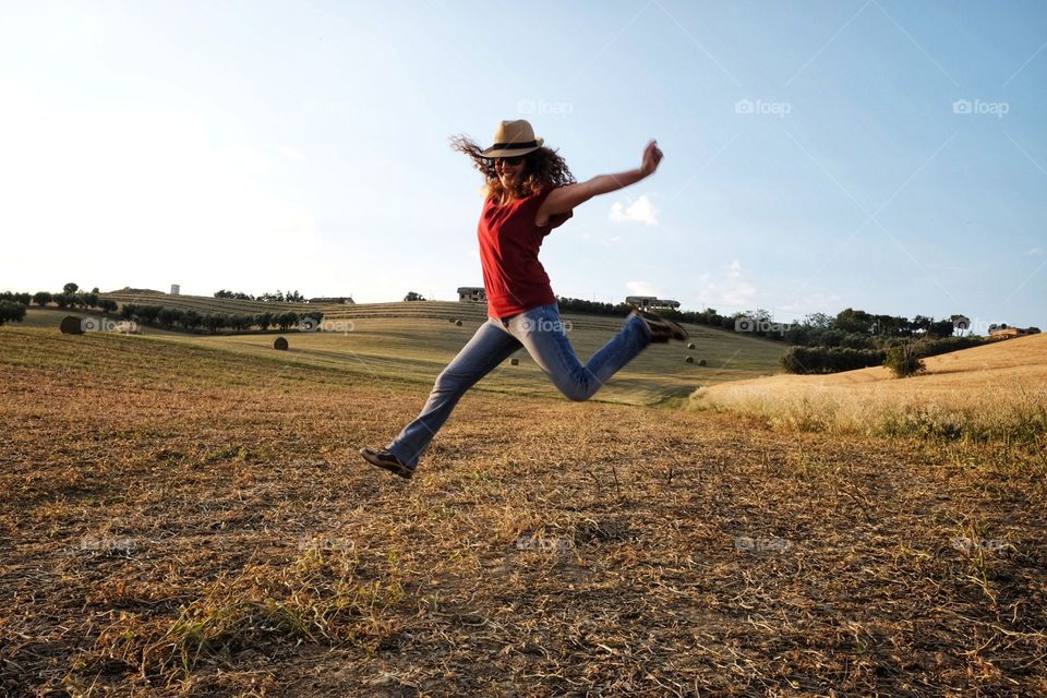 Woman jumps between hay bales in the countryside