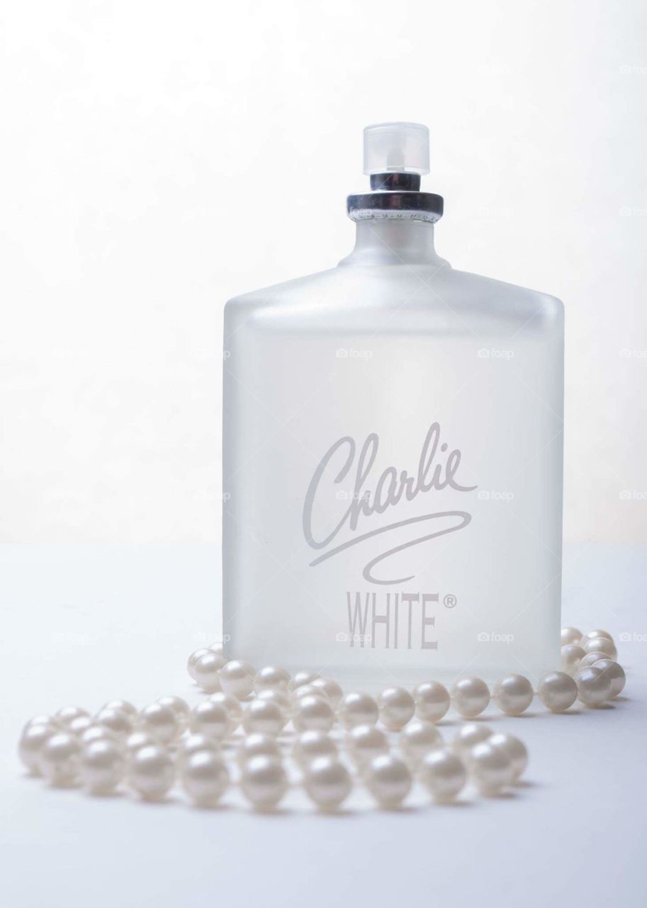 white on white Charlie perfume product image of white frosted bottle with white wording on the bottle all against a white background