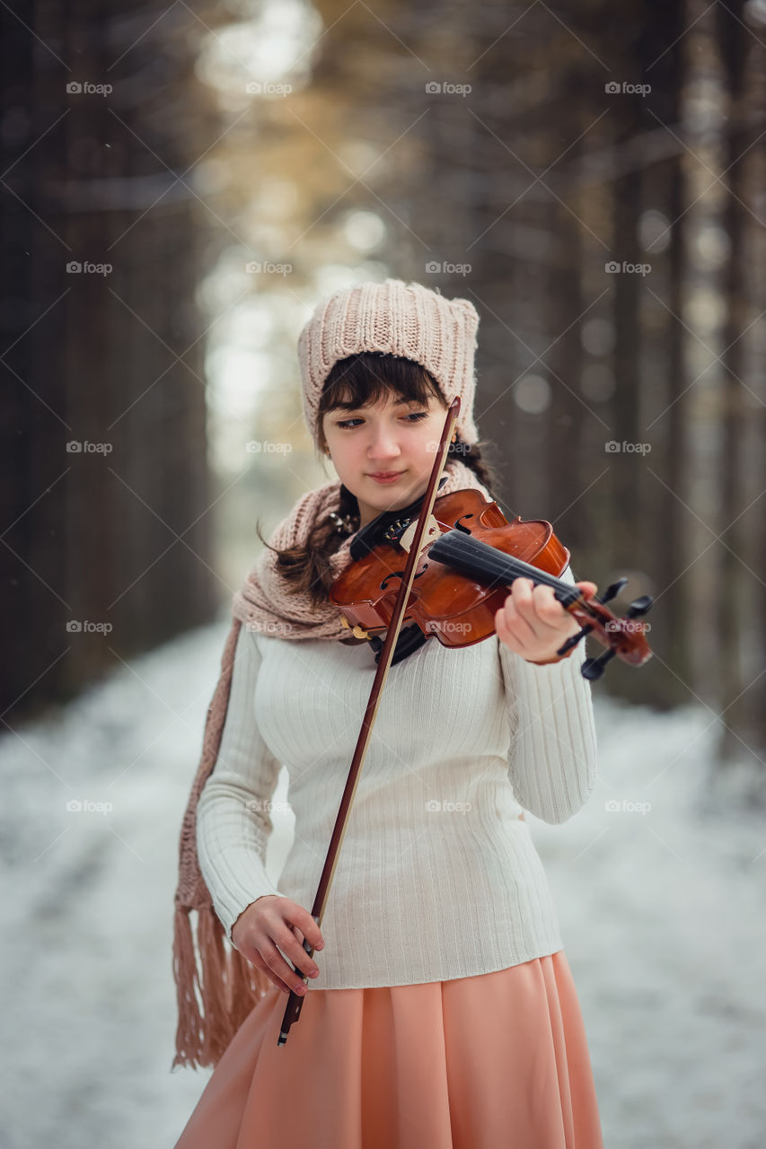 Teenage girl portrait with violin in winter park