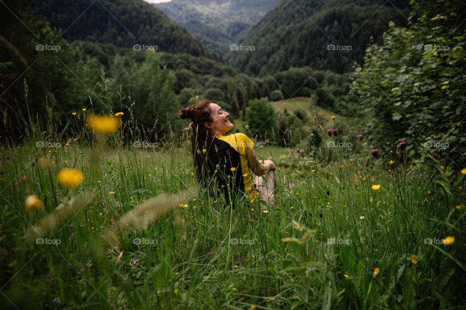 Women smiling surrounded by beautiful green nature, while on a hike in the mountains.