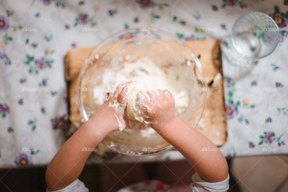 Child while playing with pasta and flour during the quarantine from Covid-19