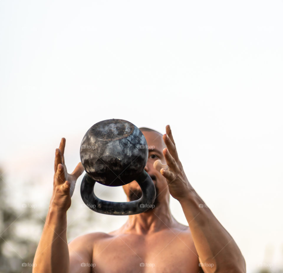 Young man doing sports throwing a kettlebell. Healthy lifestyle.