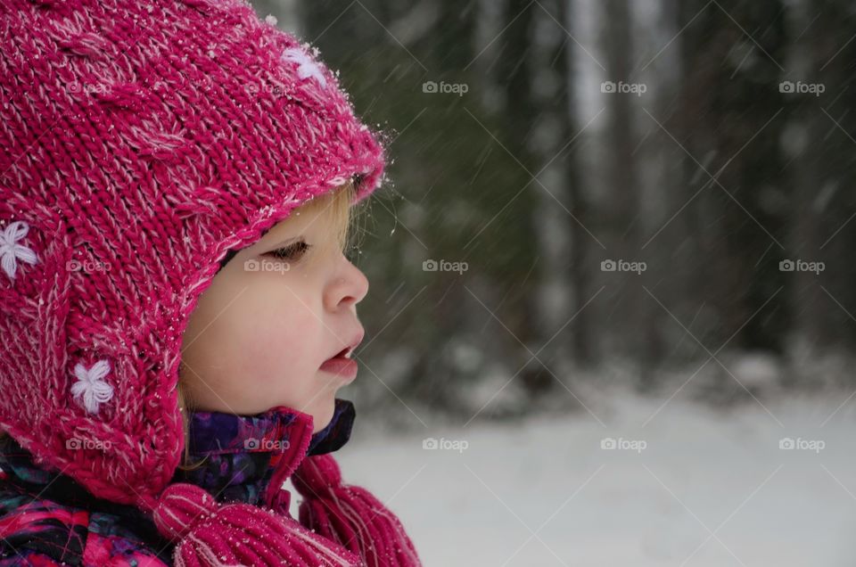 Side view of little girl during snowing