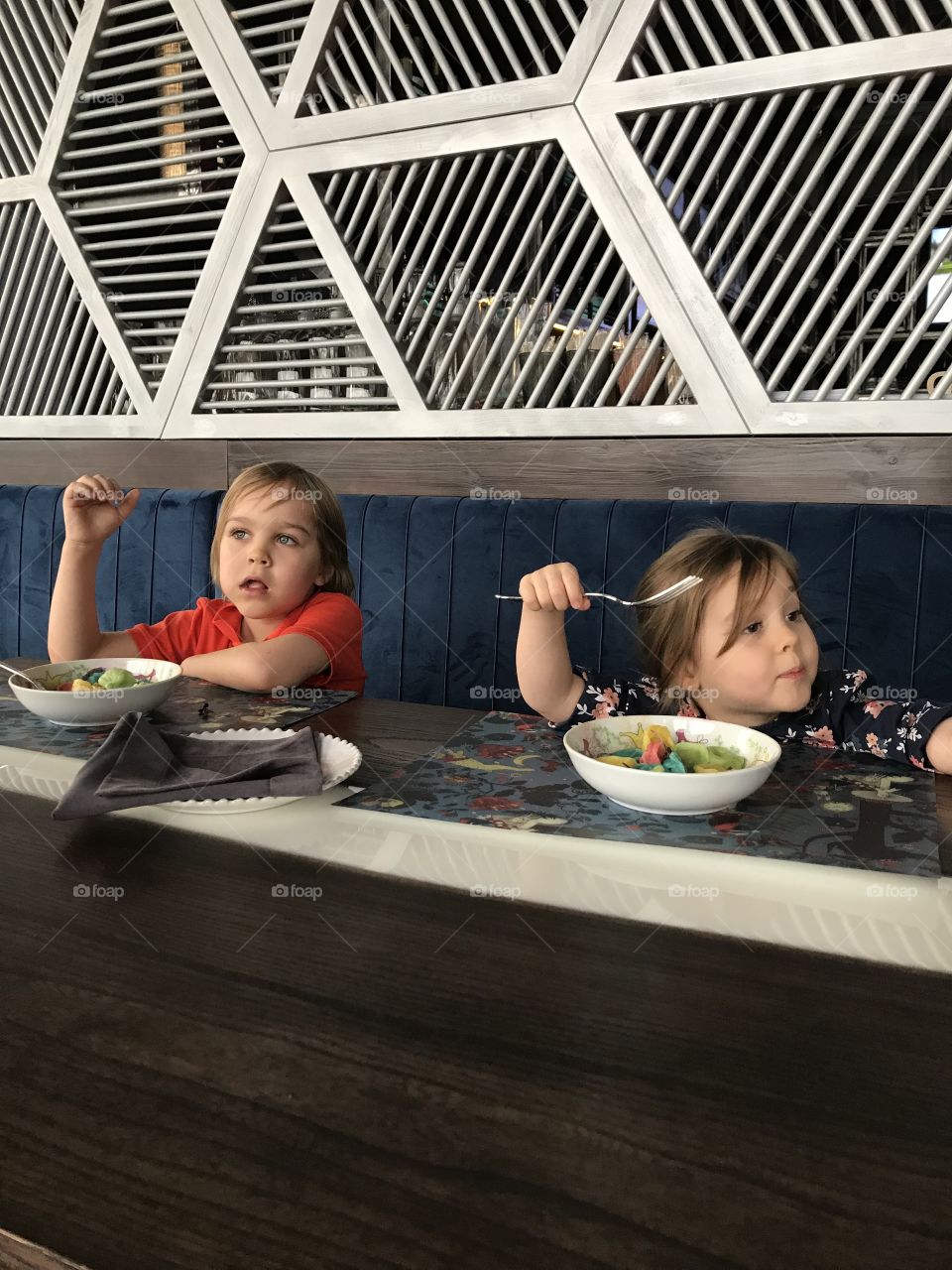 Children are eating salads  in the restaurant 