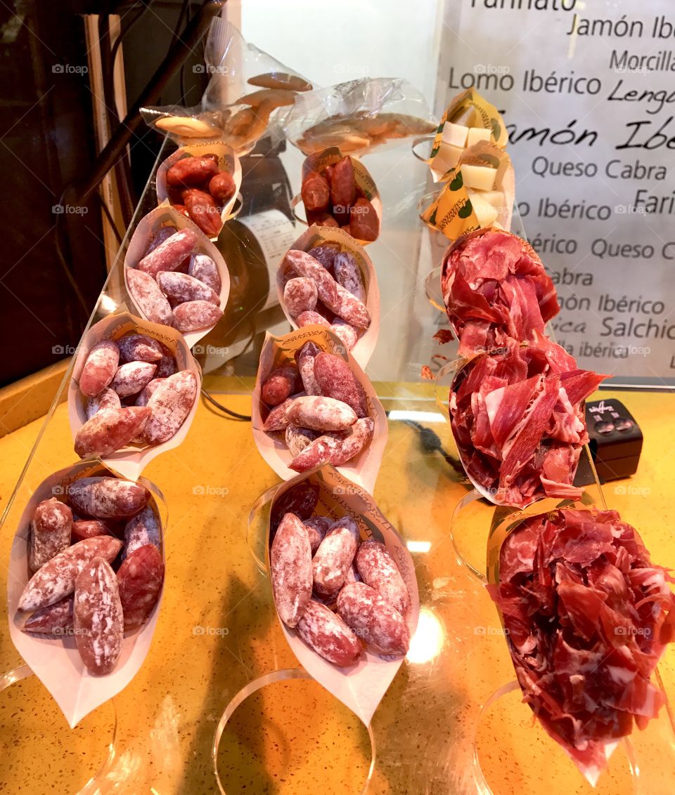 Small choriso and cut jamon in a cone. A street food snack in Madrid Spain