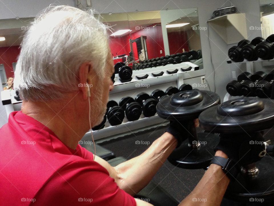 Man pumping iron to stay in good shape.
