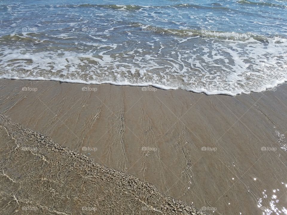 Sandy sunny beach with surf