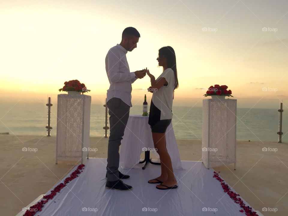 Couple proposing at beach during sunset