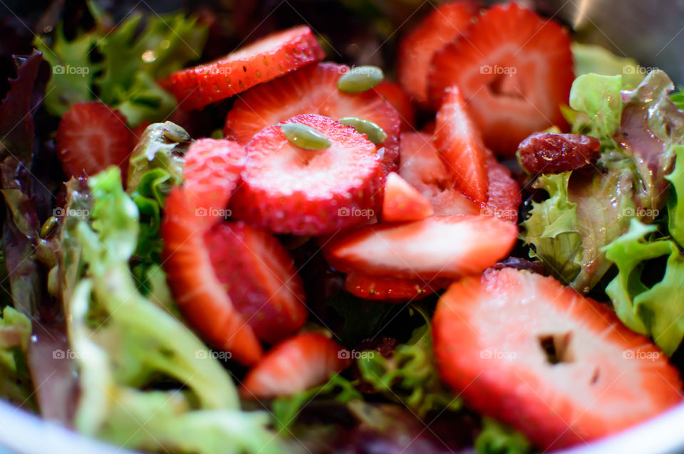 Strawberry, kale, dried cranberry and pumpkin seed salad with healthy greens and superfoods 