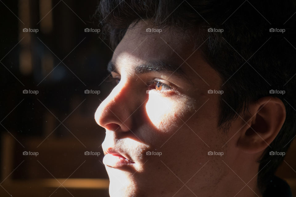 Young man's face cast in a strong shadow