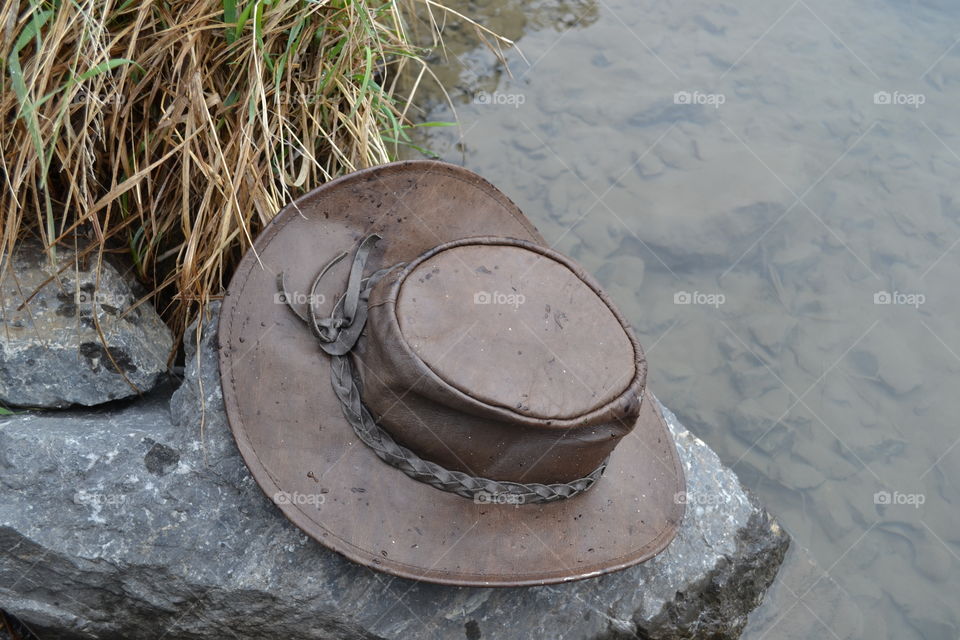 Australian leather bush hat on rock in lake near Banff in Rocky Mountains, Canada 