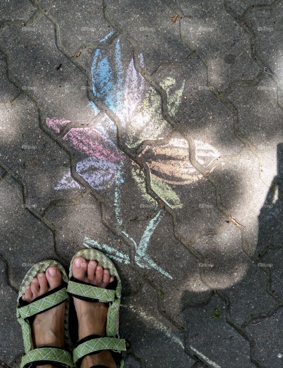 drawing colorful flower and female legs on a street pavement