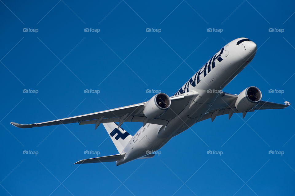 Helsinki, Finland - 9 June 2017: Finnair Airbus A350 XWB airliner flying on blue sky over Helsinki at the Kaivopuisto Air Show 2017.