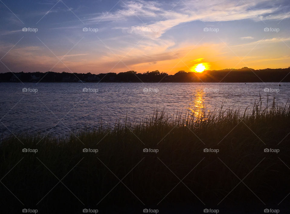 Goodnight sun...sunset over the Bass River on Cape Cod.  Marsh grass is silhouetted by the golden light.