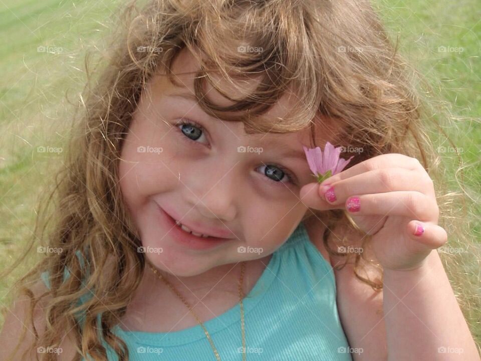 Close-up of a girl holding small flower in hand