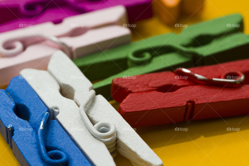 color decorative clothespins on a  yellow background. colored world in close up