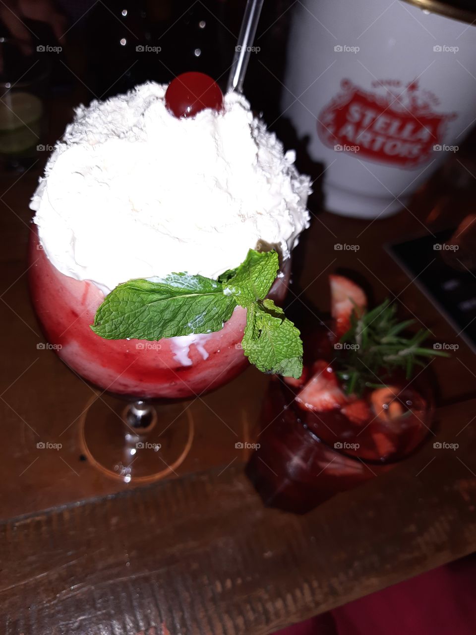 Strawberry drink with whipped cream and strawberry caipirinha