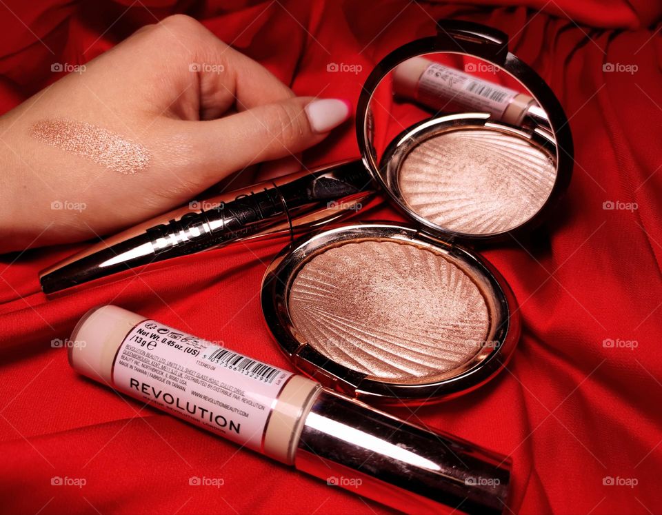 Makeup products / Highlighter, concealer and mascara / Makeup with red background / Beauty products / Beauty accessories /Product photography