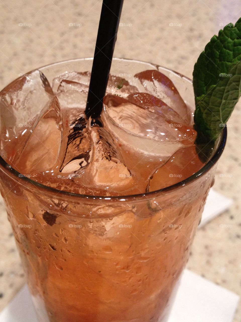 An alcoholic beverage with a fresh mint leaf