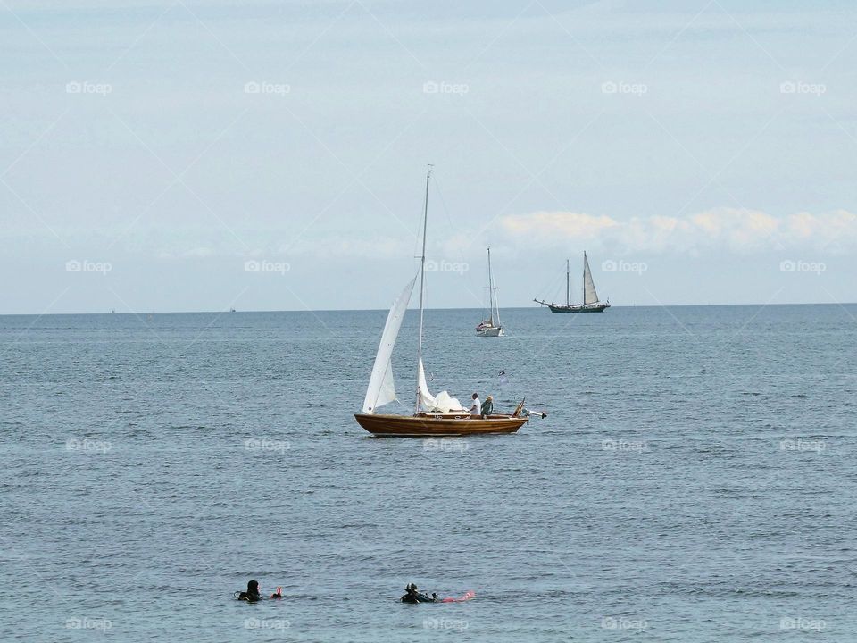 sailboats and divers on the beach