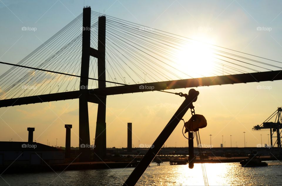 An architecturally unique bridge that crosses over the Savannah river of Georgia is seen in silhouette as the sun begins to set.