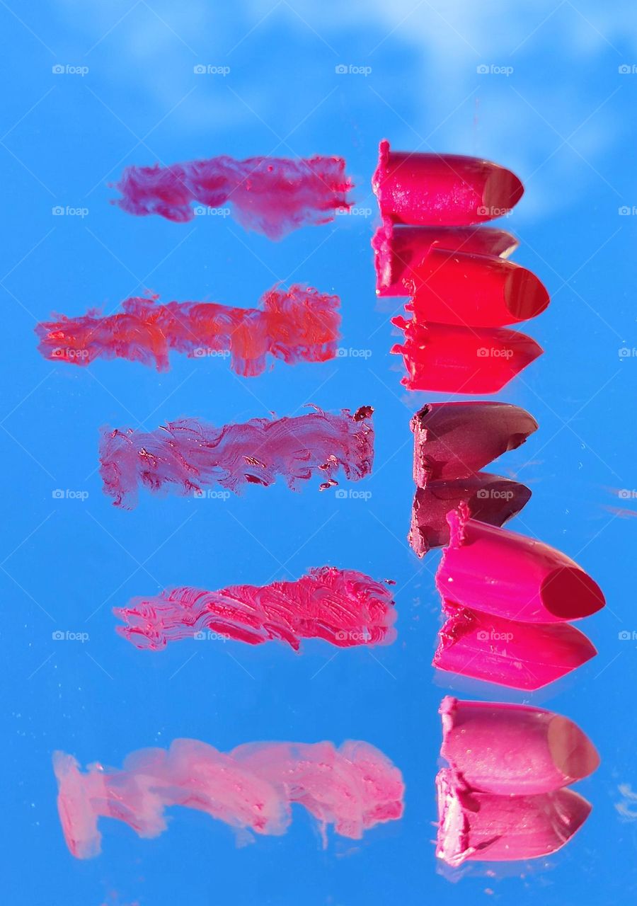 On the mirror surface, there are brushstrokes and lipsticks to them in five colors: dark red, three shades of red and pink.  It also reflects the blue sky with a white cloud