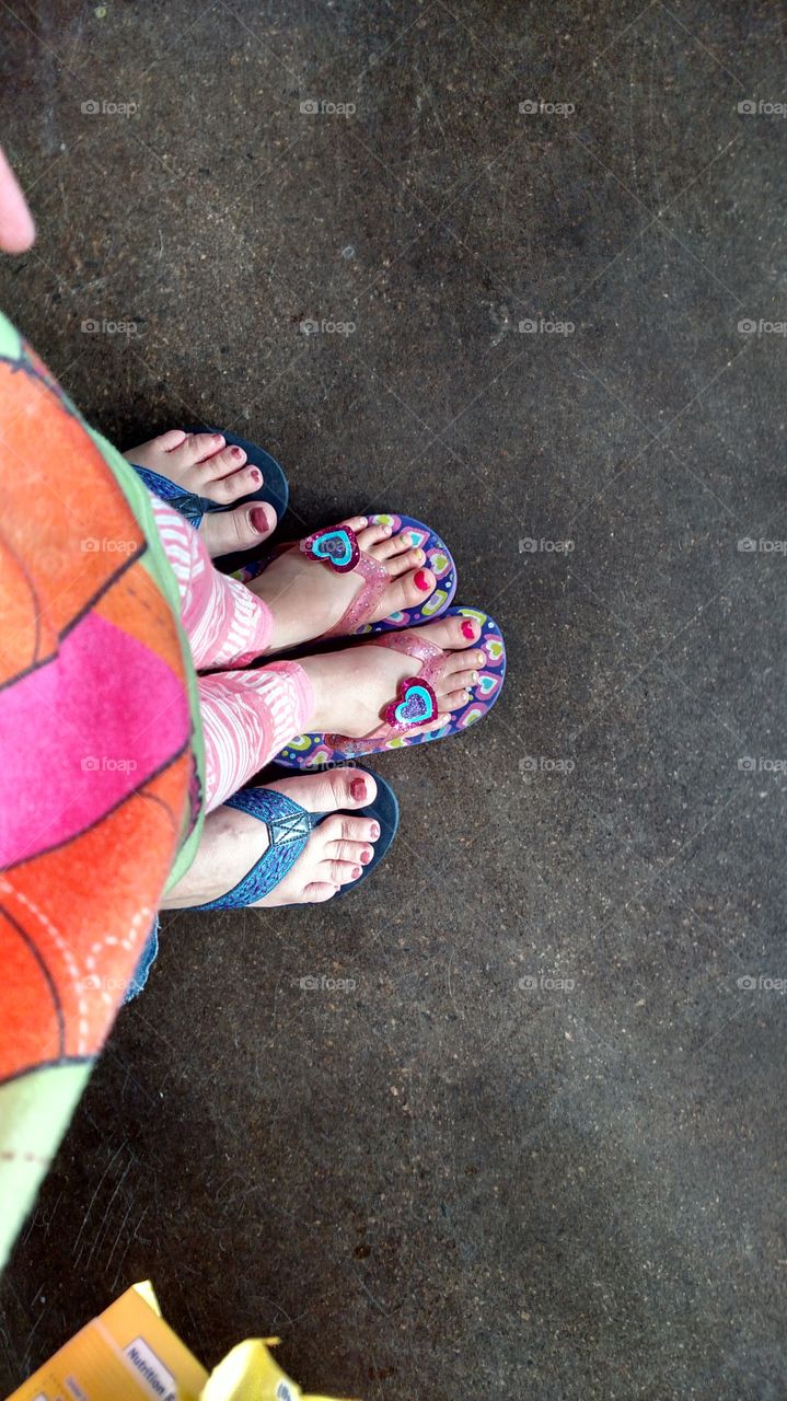 Grandma and grand daughter showing off toes and flip flops