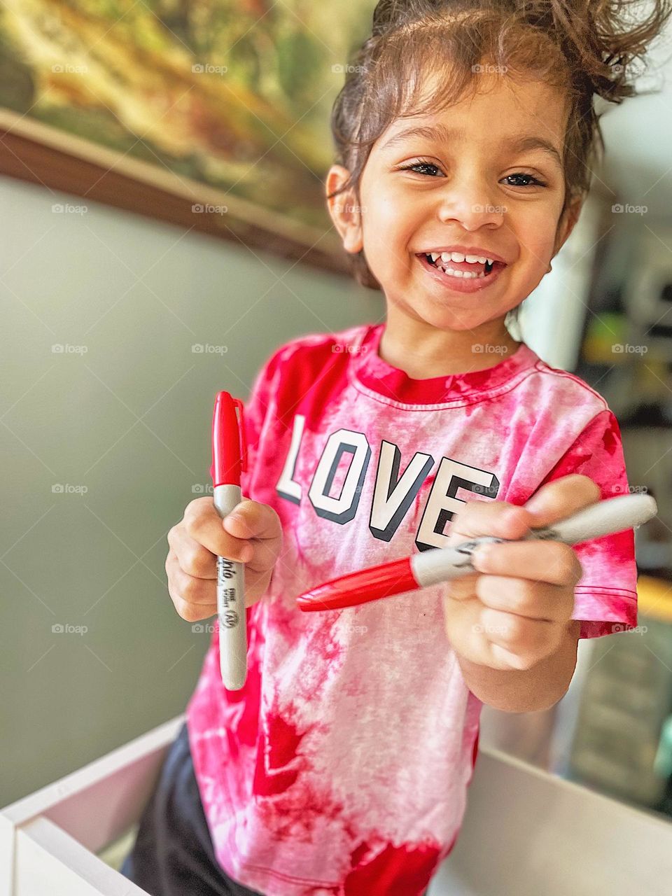 Toddler girl is happy with Sharpie markers, toddler girl showing happiness, toddler girl smiles for camera, toddler happily doing crafts, joyful toddler