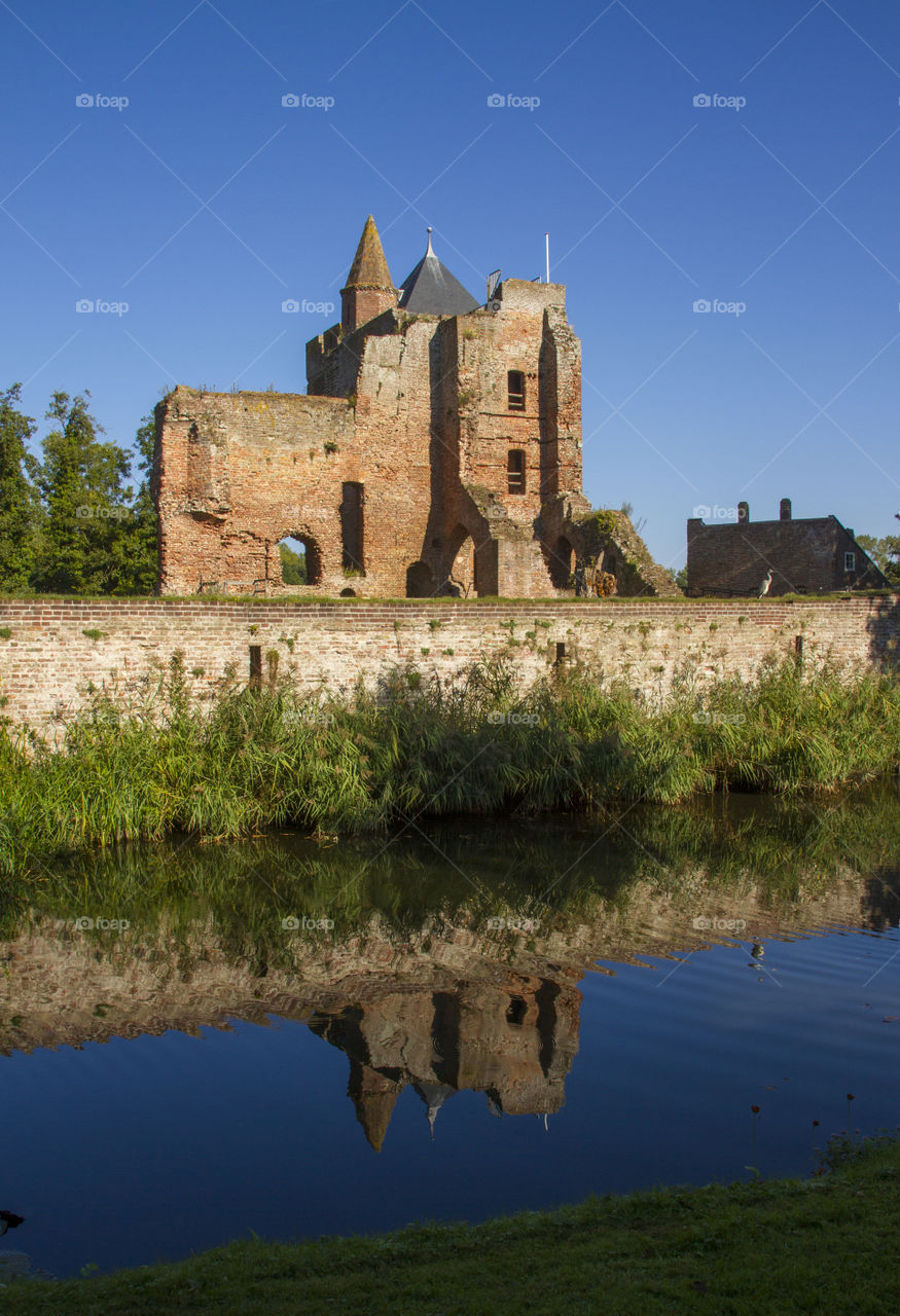 Old castle ruin reflects in the water
