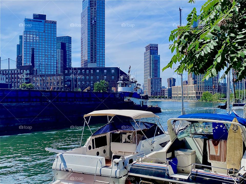 The barge is now coming closer and closer on the “East River” at “Newtown Creek” by the “Pulaski Bridge” in LIC, Queens. Across the water you can see “Greenpoint”, Brooklyn with some industrial buildings. 2023. Hypnotic Productions
