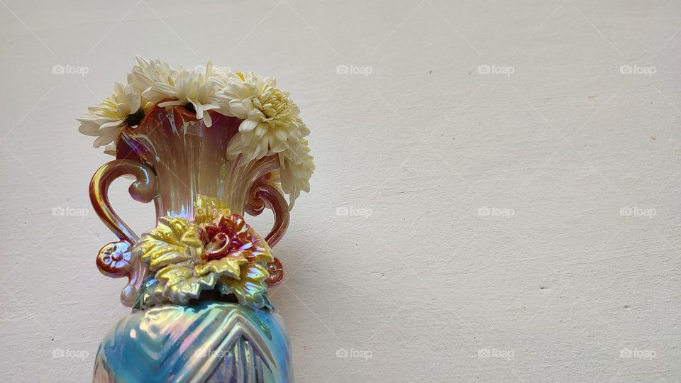 Beautiful white flowers in a colourful flowerpot with a flower sculpture, Flowers in a vase, colourful vase, white flowers in a vase