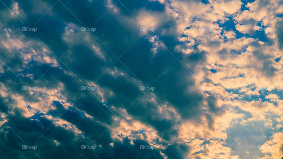 Large clouds float across the sunset sky like sails.