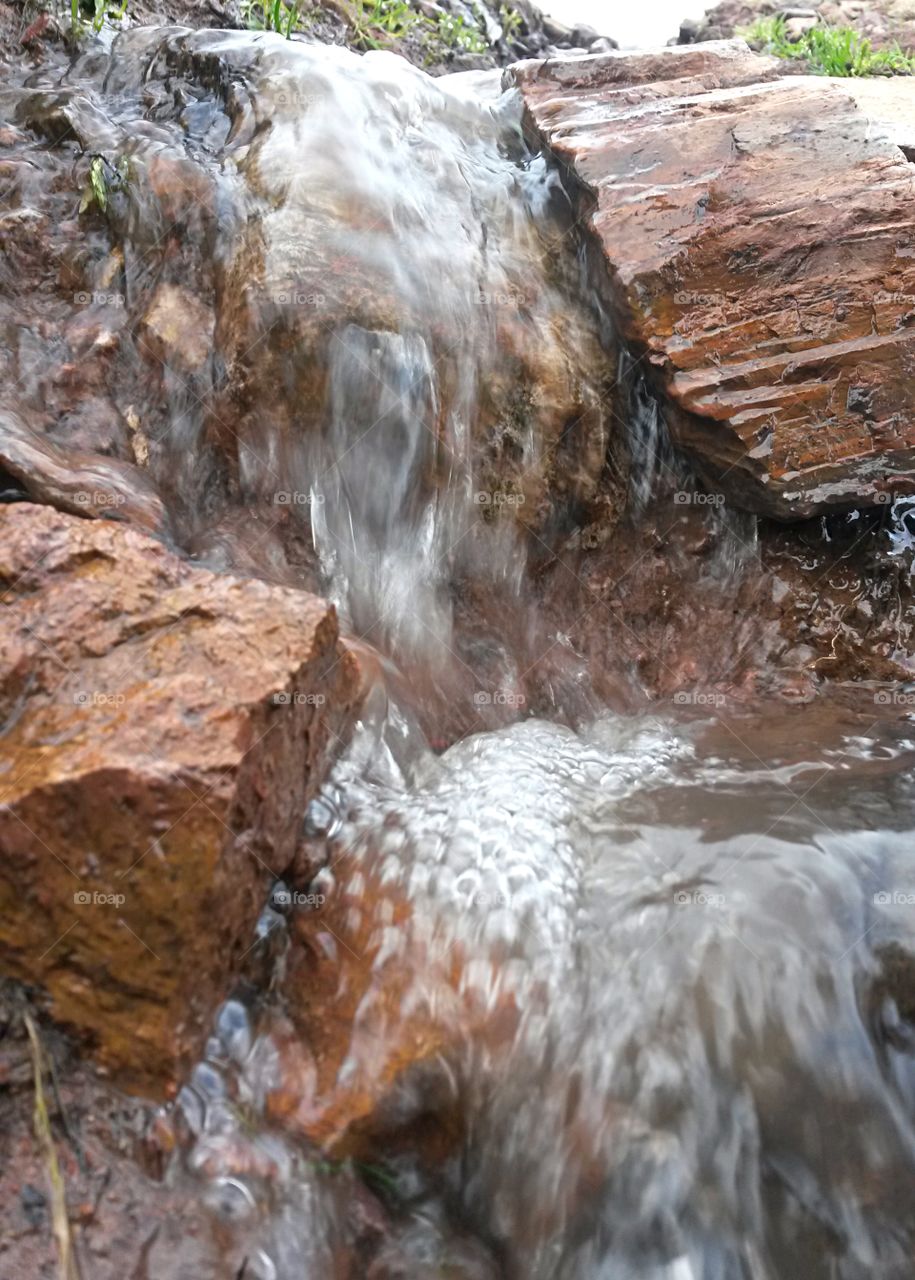 particular of little water stream into granite rock