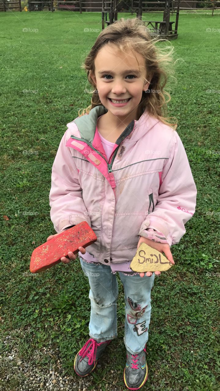 The rocks she found at the playground are making her do what it says. Smile! The beginning of our painted rock adventures. 